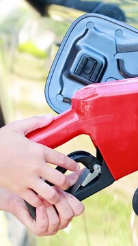 Person Refueling Car at Outdoor Gas Station Pump