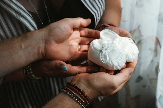 Hands Holding Baby Shoes Symbolizing Expectant Parents