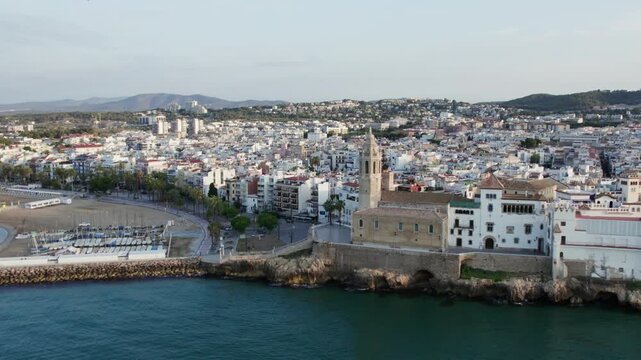 Aerial view of the Church of Sant Bartomeu and Santa Tecla with the beautiful coastal cityscape, a blend of history and modernity, Sitges, Barcelona, Spain.