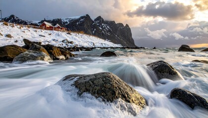 Snowy coastal landscape with waves crashing over rocks, cabins, and mountains