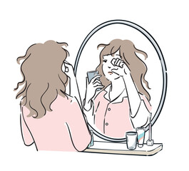 スマホを持って鏡の前に立つパジャマ姿の女性