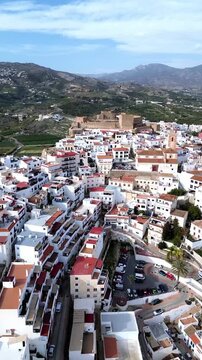 Aerial view of white village near Velez Malaga, Salobre&ntilde;a, Spain, with historic castle and mountains.