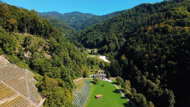 Aerial view of Mines de Sel de Bex, nestled amid lush green hills and structured vineyards, creating a picturesque Swiss landscape, Bex, Vaud, Switzerland.