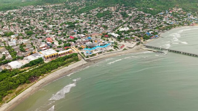 Panoramic aerial dolly in view showing the beautiful coastline and urban landscape of puerto colombia