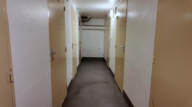 POV of A Person Walking Oh The Hallway Along The Doors.