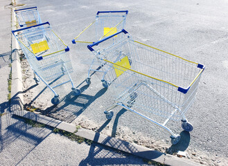 Supermarket carts in the parking lot. Empty metal carts and baskets on the asphalt near the store.