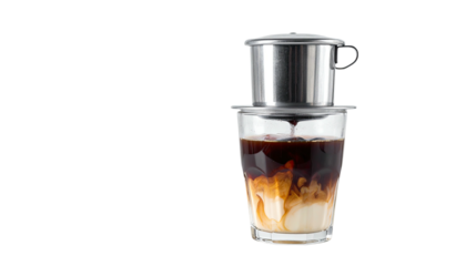 Metal coffee drip filter over a glass, mixing with milk. Black background