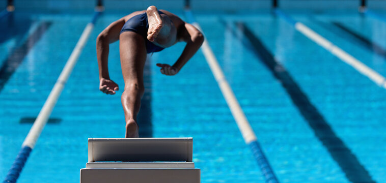 The swimmer jumps from the start block at the start of the race