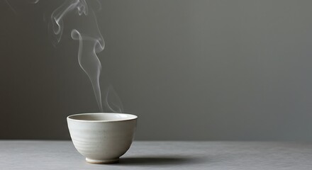 A quiet moment with a steaming cup of hot tea on a gray surface in a minimalist setting