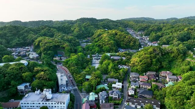 Aerial view of the city of Kamakura and the Great Buddha, with lush green trees and mountains, a cityscape with houses and buildings, Kamakura, Tokyo, Japan.