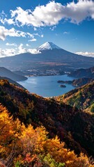 Autumn vista of Mount Fuji over a lake.  Colorful foliage blankets hillsides overlooking a serene body of water, with the iconic snow-capped peak of Mount Fuji prominently featured in the background