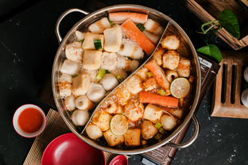 Close Up Taiwanese hot pot with various steamboat included crab sticks, fish balls, and tofu. Top View 