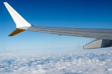 The wing of an airplane can be seen clearly extending above the clouds