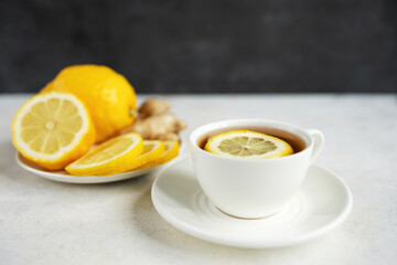 Natural cold and flu remedy with cup of tea, lemon and ginger, health and wellness concept
