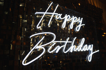 Bright neon birthday sign lights up celebration in festive venue at night