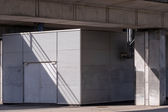 In Copenhagen, Denmark, concrete wall meets metallic garage door, with industrial simplicity and geometric order, revealing modern design within Denmark, as texture and light shape minimal c