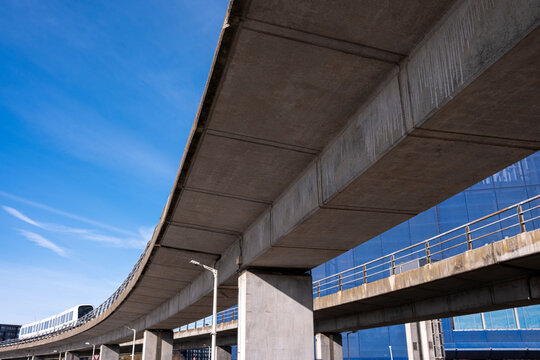 In Copenhagen, Denmark, curved bridge meets concrete structure, with blue sky and modern infrastructure, revealing geometry within Denmark, as lines and light shape urban composition and Cop