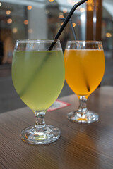 Kombucha. A refreshing kombucha drink with mango and apple flavors served in a beautiful glass with a straw. Served in restaurants and cafes.