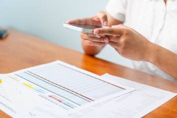 Analyzing financial data a smartphone at a desk home office daily task elevated perspective