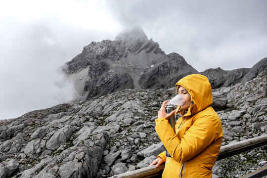 Woman recovering from altitude sickness using canned oxygen during cold mountain travel - Powered by Adobe
