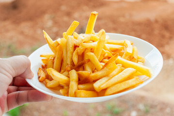 Delicious handheld french fries served outdoors tasty snack natural setting close-up view
