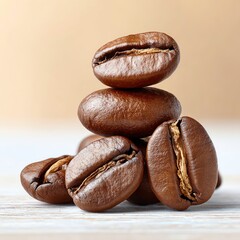 A close-up of fresh, roasted coffee beans stacked beautifully on a light wooden surface.