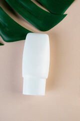 Cosmetic product in tube, bottle, lotion or serum with stylish props on light brown background. 