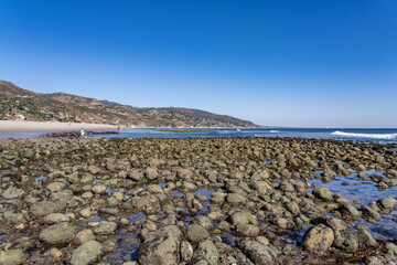 Alluvial gravel, sand and clay of flood plains. Malibu Lagoon State Beach, Malibu is a beach city in the Santa Monica Mountains region of Los Angeles County, California. intertidal zone