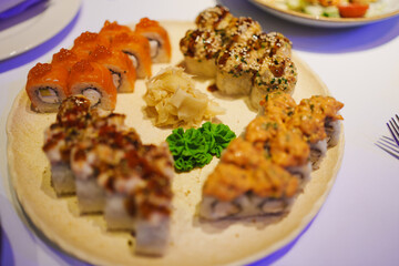 Delicious sushi platter featuring various rolls and garnishes at dinner