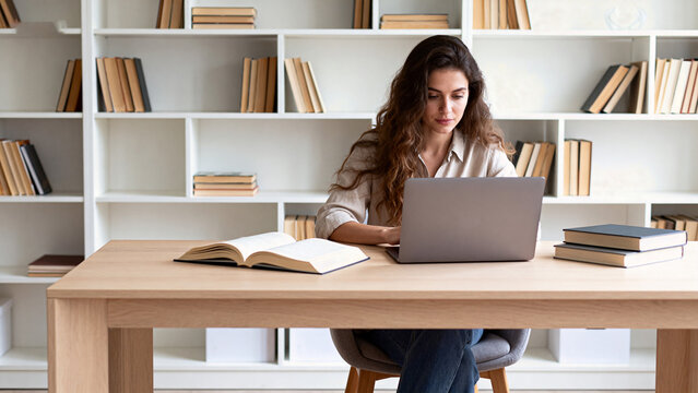 Woman working on laptop in library
