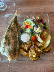 Grilled fish with potato and salad.
