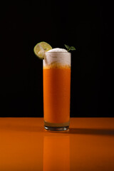 A fresh orange smoothie standing on orange table