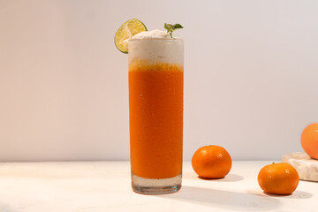 A fresh orange smoothie standing on white table