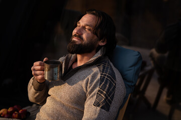 Relaxing outdoors with a warm drink during a sunny evening in nature