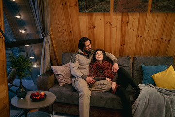 Cozy evening in a wooden cabin with a couple enjoying each other's company