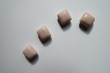 Four pink rectangular pieces of chewing gum from above