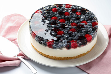 Delicious cheesecake with berries served on white table, closeup