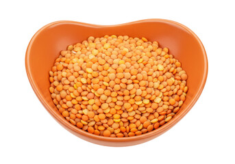 Isolated lentil soup ingredient, red split lentils in an orange-colored ceramic bowl on table
