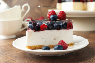 Piece of delicious cheesecake with berries on wooden table, closeup