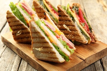 Tasty sandwiches with different fillings on wooden table, closeup