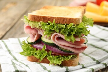 Tasty sandwich with ham and vegetables on table, closeup