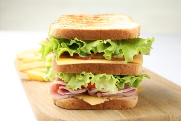 Tasty sandwich served with french fries on white table, closeup
