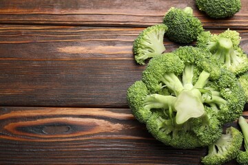 Fresh raw broccoli on wooden table, flat lay. Space for text
