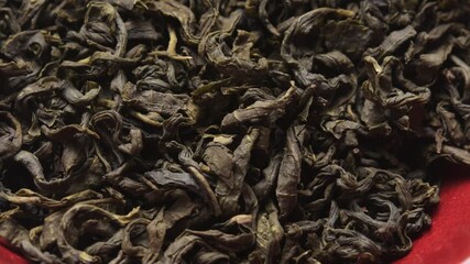 Rotating close up of dried green tea leaves in bowl, showing curled texture and rich natural color, vibrant detail for healthy tea lovers - Powered by Adobe