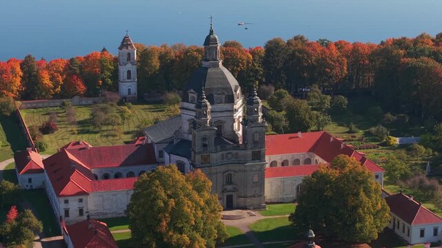 Aerial view of Pažaislis Monastery in Kaunas, Lithuania, surrounded by vibrant autumn trees near the Kaunas Reservoir. A stunning example of Baroque architecture and cultural heritage.