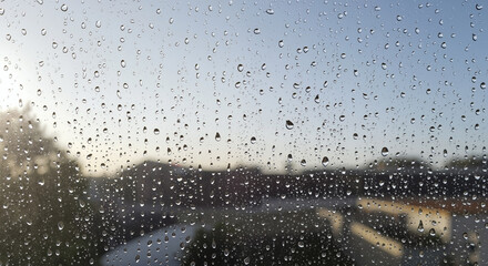 Raindrops on window glass. Close-up of water drops after rain with blurred background. Abstract weather texture