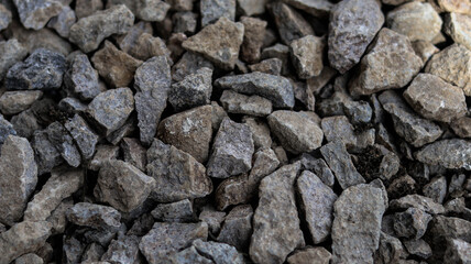 Close-up of compact gravel surface with mixed stone colors and rough texture. Ideal for...