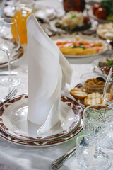 Elegant table with white napkin and tasty food at festive gathering