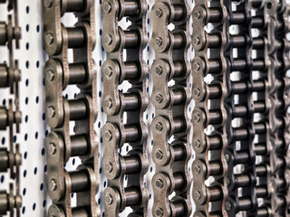 Different types of metal chains displayed in a workshop environment with a focus on craftsmanship