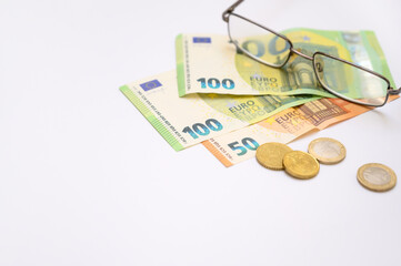 European money and glasses on white surface representing financial planning, taxation, and economic analysis. Great choice for websites, reports, or financial marketing materials.